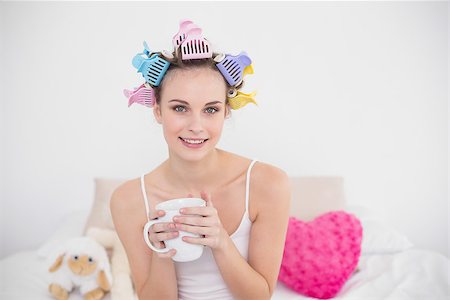simsearch:400-07129766,k - Pleased natural brown haired woman in hair curlers holding a cup of coffee in bright bedroom Stock Photo - Budget Royalty-Free & Subscription, Code: 400-07129722