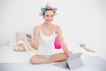 simsearch:400-07129766,k - Joyful natural brown haired woman in hair curlers shopping online with her tablet pc in bright bedroom Stock Photo - Budget Royalty-Free & Subscription, Code: 400-07129734