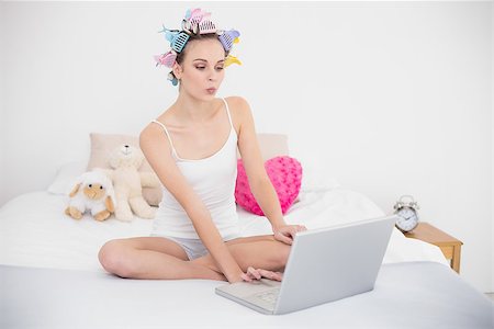 simsearch:400-07129766,k - Pouting natural brown haired woman in hair curlers using a laptop in bright bedroom Stock Photo - Budget Royalty-Free & Subscription, Code: 400-07129737