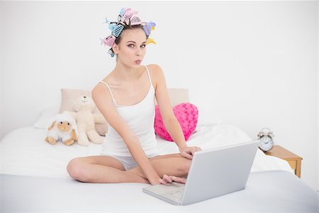 simsearch:400-07129766,k - Funny natural brown haired woman in hair curlers using a laptop in bright bedroom Stock Photo - Budget Royalty-Free & Subscription, Code: 400-07129738