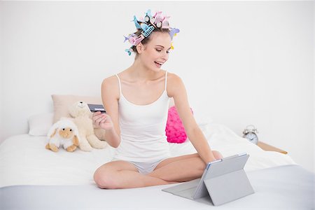 simsearch:400-07129766,k - Pretty natural brown haired woman in hair curlers shopping online with her tablet pc in bright bedroom Stock Photo - Budget Royalty-Free & Subscription, Code: 400-07129733