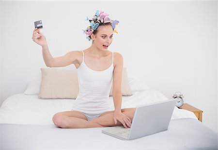 simsearch:400-07129766,k - Amazed natural brown haired woman in hair curlers shopping online with a computer in bright bedroom Stock Photo - Budget Royalty-Free & Subscription, Code: 400-07129744