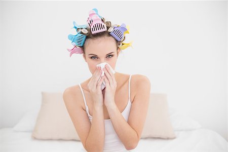 simsearch:400-07129766,k - Cute natural brown haired woman in hair curlers sneezing in a tissue in bright bedroom Stock Photo - Budget Royalty-Free & Subscription, Code: 400-07129767
