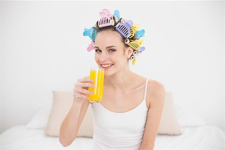 simsearch:400-07129766,k - Cute natural brown haired woman in hair curlers drinking orange juice in bright bedroom Stock Photo - Budget Royalty-Free & Subscription, Code: 400-07129774