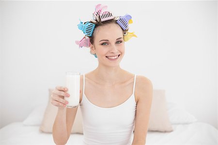 simsearch:400-07129766,k - Casual natural brown haired woman in hair curlers holding a glass of milk in bright bedroom Stock Photo - Budget Royalty-Free & Subscription, Code: 400-07129775