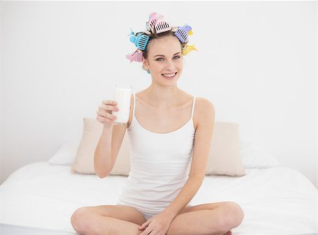 simsearch:400-07129766,k - Pretty natural brown haired woman in hair curlers holding a glass of milk in bright bedroom Stock Photo - Budget Royalty-Free & Subscription, Code: 400-07129776