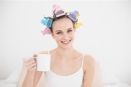 simsearch:400-07129766,k - Amused natural brown haired woman in hair curlers holding a mug of coffee in bright bedroom Stock Photo - Budget Royalty-Free & Subscription, Code: 400-07129779