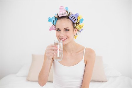 simsearch:400-07129766,k - Content natural brown haired woman in hair curlers drinking water in bright bedroom Stock Photo - Budget Royalty-Free & Subscription, Code: 400-07129772