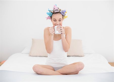 simsearch:400-07129766,k - Calm natural brown haired woman in hair curlers enjoying coffee smell in bright bedroom Stock Photo - Budget Royalty-Free & Subscription, Code: 400-07129782