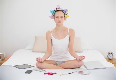 simsearch:400-07129766,k - Peaceful natural brown haired woman in hair curlers meditating in lotus position in bright bedroom Stock Photo - Budget Royalty-Free & Subscription, Code: 400-07129815