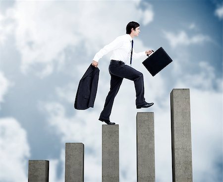 simsearch:6109-06684997,k - Young businessman climbing grey steps on sky background Stock Photo - Budget Royalty-Free & Subscription, Code: 400-07138054