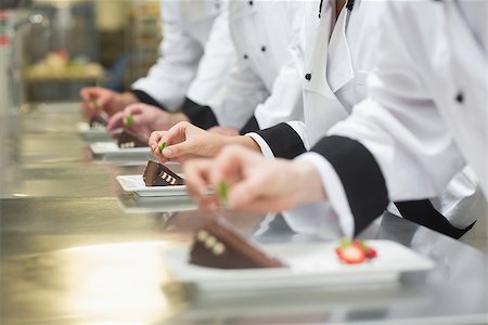 Team of chefs garnishing dessert plates in a busy kitchen Stock Photo - Budget Royalty-Free & Subscription, Code: 400-07139978