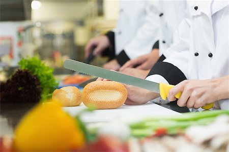 Close up of chef slicing bread roll in a kitchen Stock Photo - Budget Royalty-Free & Subscription, Code: 400-07140011
