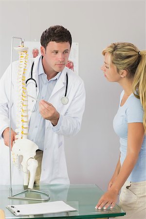 pelvic woman - Calm doctor showing a patient something on skeleton model in bright office Stock Photo - Budget Royalty-Free & Subscription, Code: 400-07140129