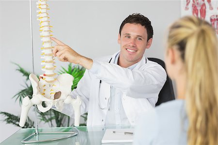 pelvic woman - Smiling doctor showing a patient something on skeleton model in bright office Stock Photo - Budget Royalty-Free & Subscription, Code: 400-07140123