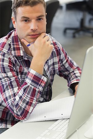 Handsome serious student using computer taking notes in computer room at college Stock Photo - Budget Royalty-Free & Subscription, Code: 400-07142096