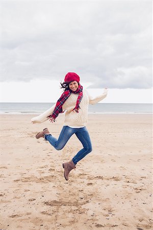 simsearch:400-07181052,k - Full length of a woman in stylish warm clothing jumping at the beach Stock Photo - Budget Royalty-Free & Subscription, Code: 400-07142249