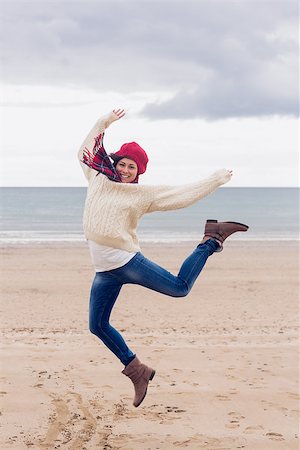 simsearch:400-07181052,k - Full length of a woman in stylish warm clothing jumping at the beach Stock Photo - Budget Royalty-Free & Subscription, Code: 400-07142252