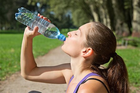 Attractive sporty woman drinking water from a bottle after jogging or running Stock Photo - Budget Royalty-Free & Subscription, Code: 400-07169087