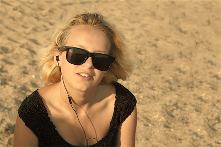 sandi model - Beautiful young blond girl with glasses and headphones on the background of a sandy beach, edited with sepia Stock Photo - Budget Royalty-Free & Subscription, Code: 400-07170605