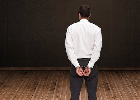 Composite image of rear view of young businessman wearing handcuffs Stock Photo - Budget Royalty-Free & Subscription, Code: 400-07186246