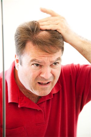 sad bald man - Man in his forties looking in the mirror discovers a bald spot in his hair. Stock Photo - Budget Royalty-Free & Subscription, Code: 400-07180003