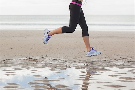simsearch:400-04535435,k - Low section of a healthy young woman jogging on shore at beach Stock Photo - Budget Royalty-Free & Subscription, Code: 400-07180898