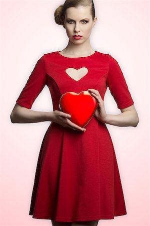 pretty blonde girl with creative hair-style and red romantic dress taking in the hands one hearth shaped box Stock Photo - Budget Royalty-Free & Subscription, Code: 400-07224145