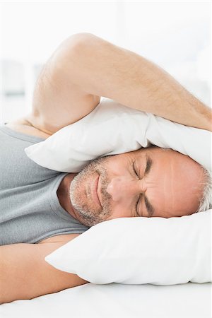 simsearch:700-03613009,k - Close-up of a mature sleepy man covering ears with pillow in bed at home Stock Photo - Budget Royalty-Free & Subscription, Code: 400-07230674