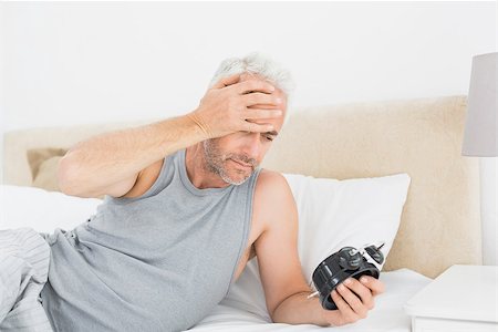 simsearch:700-03613009,k - Mature man looking at alarm clock in bed at home Stock Photo - Budget Royalty-Free & Subscription, Code: 400-07230679