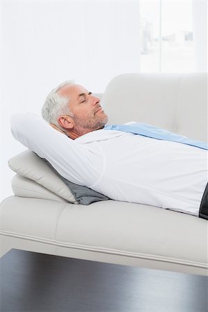 Side view of a tired mature businessman sleeping on sofa in the living room at home Stock Photo - Budget Royalty-Free & Subscription, Code: 400-07230754