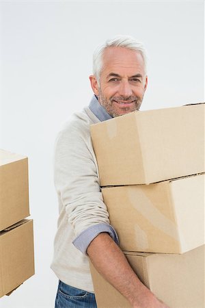 simsearch:400-07930718,k - Portrait of a smiling mature man carrying boxes against white background Stock Photo - Budget Royalty-Free & Subscription, Code: 400-07230865