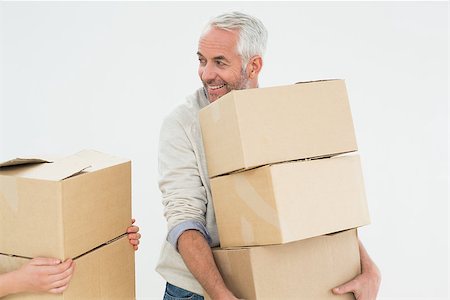 simsearch:400-07930718,k - Smiling mature man carrying boxes against white background Stock Photo - Budget Royalty-Free & Subscription, Code: 400-07230867