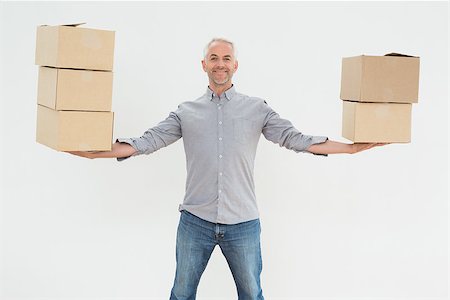 simsearch:400-07930718,k - Portrait of a smiling mature man carrying boxes against white background Stock Photo - Budget Royalty-Free & Subscription, Code: 400-07230882