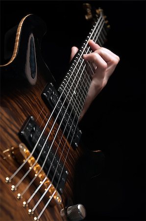 popular music concert - close up shot of male hand playing vintage brown guitar over black - shallow DOF with focus placed on strings Stock Photo - Budget Royalty-Free & Subscription, Code: 400-07250051