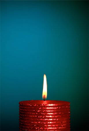 sparkling orange flame - burning wax candle on a blue background Stock Photo - Budget Royalty-Free & Subscription, Code: 400-07251543