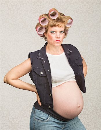 simsearch:400-06363059,k - Serious pregnant female in curlers with hands on hips Stock Photo - Budget Royalty-Free & Subscription, Code: 400-07252390