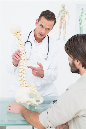 Male doctor explaining the spine to a patient in medical office Stock Photo - Budget Royalty-Free & Subscription, Code: 400-07269080