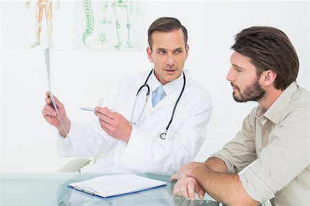 Male doctor explaining spine x-ray to patient in the medical office Stock Photo - Budget Royalty-Free & Subscription, Code: 400-07269189