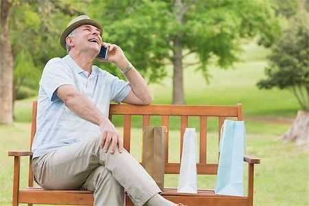 phone one person adult smile elderly - Cheerful relaxed senior man using mobile phone while sitting on bench at the park Stock Photo - Budget Royalty-Free & Subscription, Code: 400-07274913