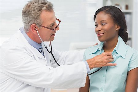 doctor with ethnic patient in office - Doctor listening to cheerful young patients chest with stethoscope in his office at the hospital Stock Photo - Budget Royalty-Free & Subscription, Code: 400-07275635