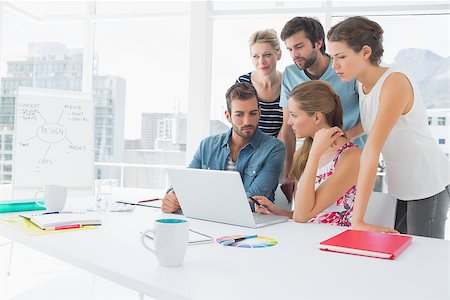 Young casual business people using laptop together in a bright office Stock Photo - Budget Royalty-Free & Subscription, Code: 400-07273471