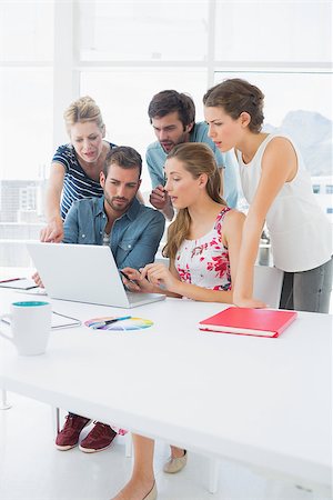 Young casual business people using laptop together in a bright office Stock Photo - Budget Royalty-Free & Subscription, Code: 400-07273472