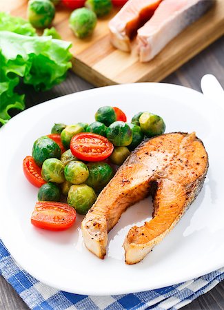 Salmon with roasted brussels sprout and tomato on a plate Stock Photo - Budget Royalty-Free & Subscription, Code: 400-07295465