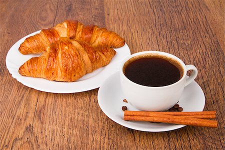 simsearch:400-07305144,k - Coffee cup with a croissant and fresh coffee beans on a wooden background Stock Photo - Budget Royalty-Free & Subscription, Code: 400-07293425