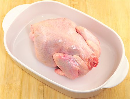 Fresh chicken in the dripping pan on the wooden table. Stock Photo - Budget Royalty-Free & Subscription, Code: 400-07304564