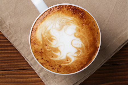 simsearch:400-07305144,k - freshly made cup of cappuccino with abstract latte art, on wooden table Stock Photo - Budget Royalty-Free & Subscription, Code: 400-07306295