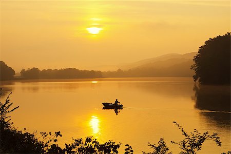 simsearch:400-06408905,k - A lone fisherman moves out on a lake in a small boat as the sun breaks through dense morning fog. Stock Photo - Budget Royalty-Free & Subscription, Code: 400-07318861