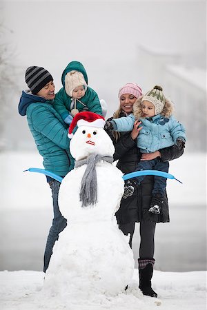 Caucasian family with two sons beside snowman outdoors Stock Photo - Budget Royalty-Free & Subscription, Code: 400-07326180