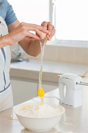 Closeup mid section of a woman cracking an egg in bowl at the kitchen Stock Photo - Budget Royalty-Free & Subscription, Code: 400-07334152